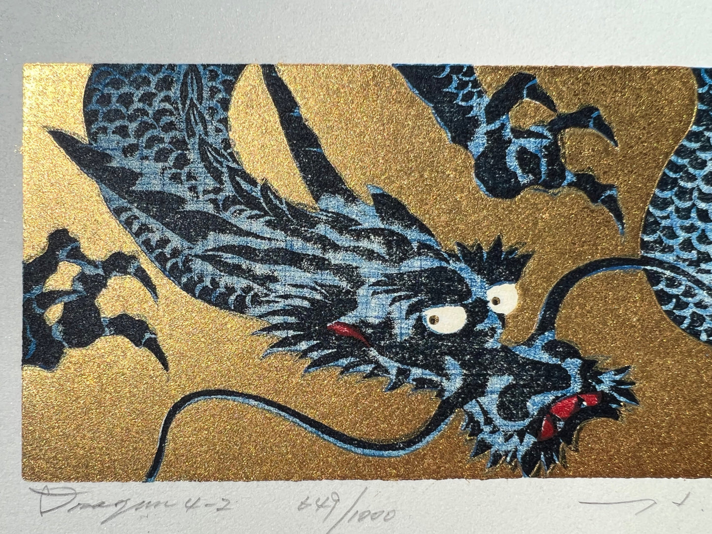 estampe japonaise dragon bleu gueule fermée sur fond or, la tête et le titre