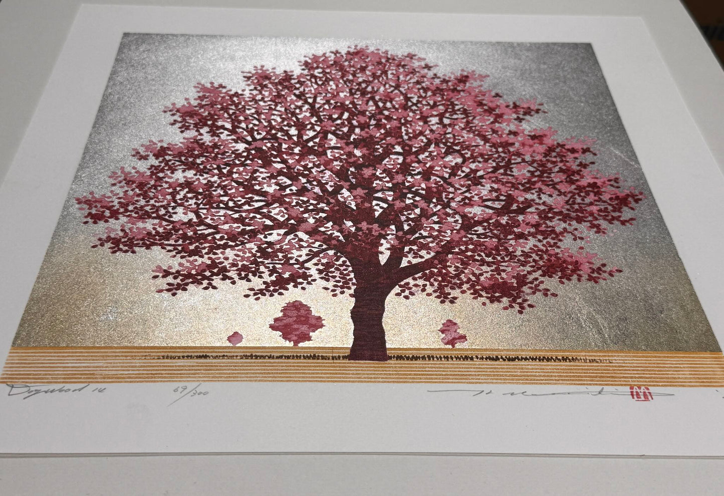 estampe japonaise de Namiki Hajime, un arbre aux fleurs rouges et roses sur fond dégradé d'argent et or, vu de profil les reflets lumineux