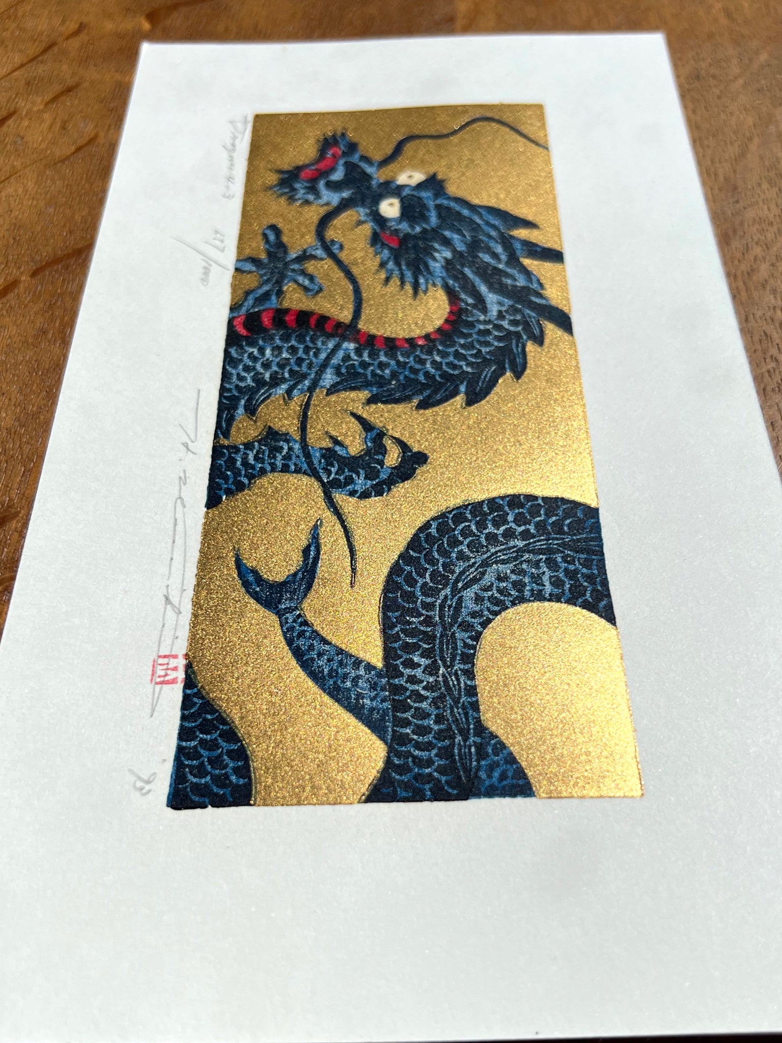 estampe japonaise dragon bleu sur fond or, gueule fermée, profil vue queue or scintillant