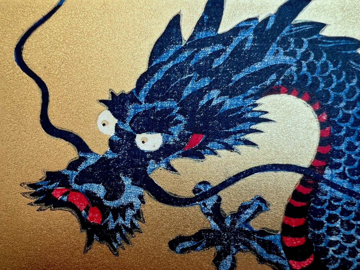 estampe japonaise dragon bleu sur fond or, gueule fermée, gros plan sur le tête avec moustache