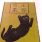 estampe japonaise de Nishida, un chat noir vu du dessous sur fond or avec calligraphie japonaise au dessus, vu de profil