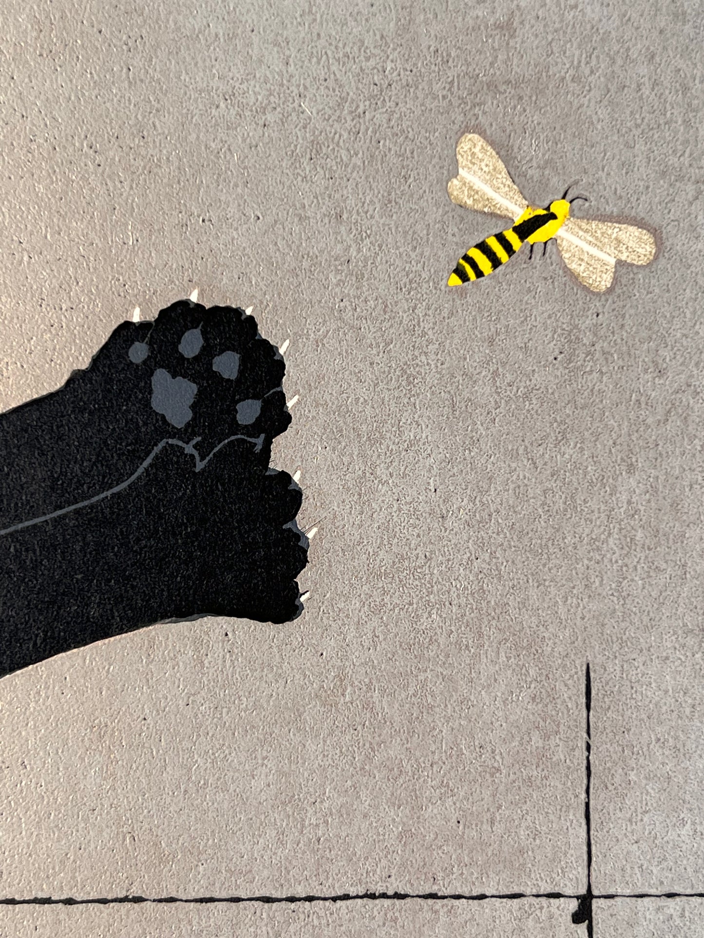 estampe japonaise chat noir sautant sur une abeille, gros plan sur l'abeille