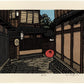 estampe japonaise de Nishijima, une ruelle de Kyoto avec maison en bois et parapluie rouge séchant au sol