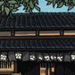 estampe japonaise facade maison traditionnelle japonaise en bois toit vernissé, sous un feuillage vert