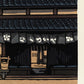 estampe japonaise facade maison traditionnelle japonaise en bois toit vernissé, la signature de l'artiste Nishijima