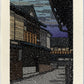 estampe japonaise de Nishijima, rue de Kyoto sous la neige, la neige tombe au premier plan, la nuit tombe, maisons traditionnelles japonaises en bois.