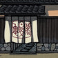 estampe japonaise contemporaine entrée restaurant poisson façade en bois et noren motif poisson stylisé, gros plan sur le noren