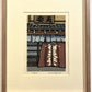 estampe japonaise contemporaine de de Nishijima,  la neige tombe devant une facade d'une maison en bois avec noren calligraphié, à Kyoto. Exemple d'encadrement avec un cadre en plat 10 chêne