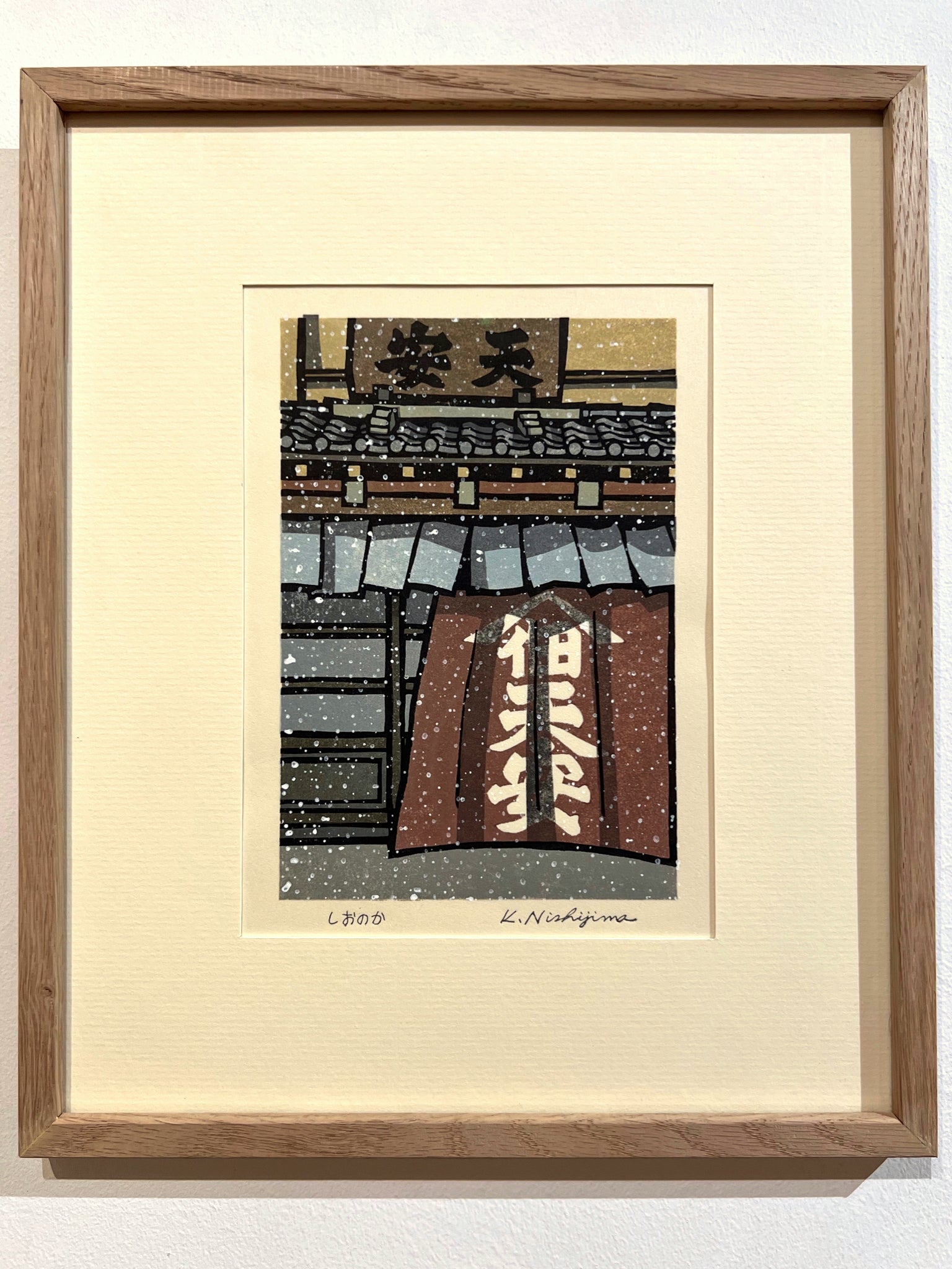 estampe japonaise contemporaine de de Nishijima,  la neige tombe devant une facade d'une maison en bois avec noren calligraphié, à Kyoto. Exemple d'encadrement avec un cadre en plat 10 chêne