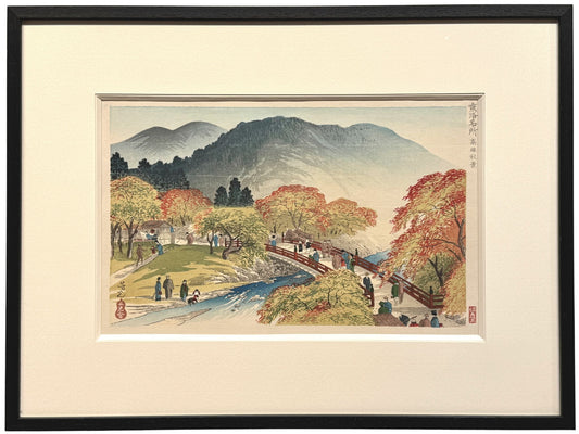 estampe japonaise encadrée de Nomura Yoshimitsu représentant un paysage d'automne avec érables rouges, pont, rivière et promeneurs. Avec cadre noir