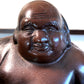 statuette en bronze cuivré de Hotei, dieu du bonheur, gros plan sur le visage souriant
