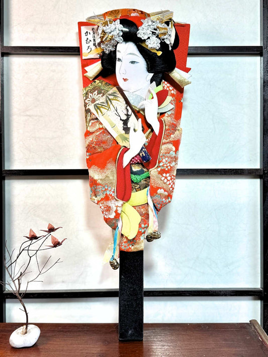 raquette décorative japonaise hagoita, femme tenant une hagoita miniature, motif bambou et prunier en fleur, vu de face