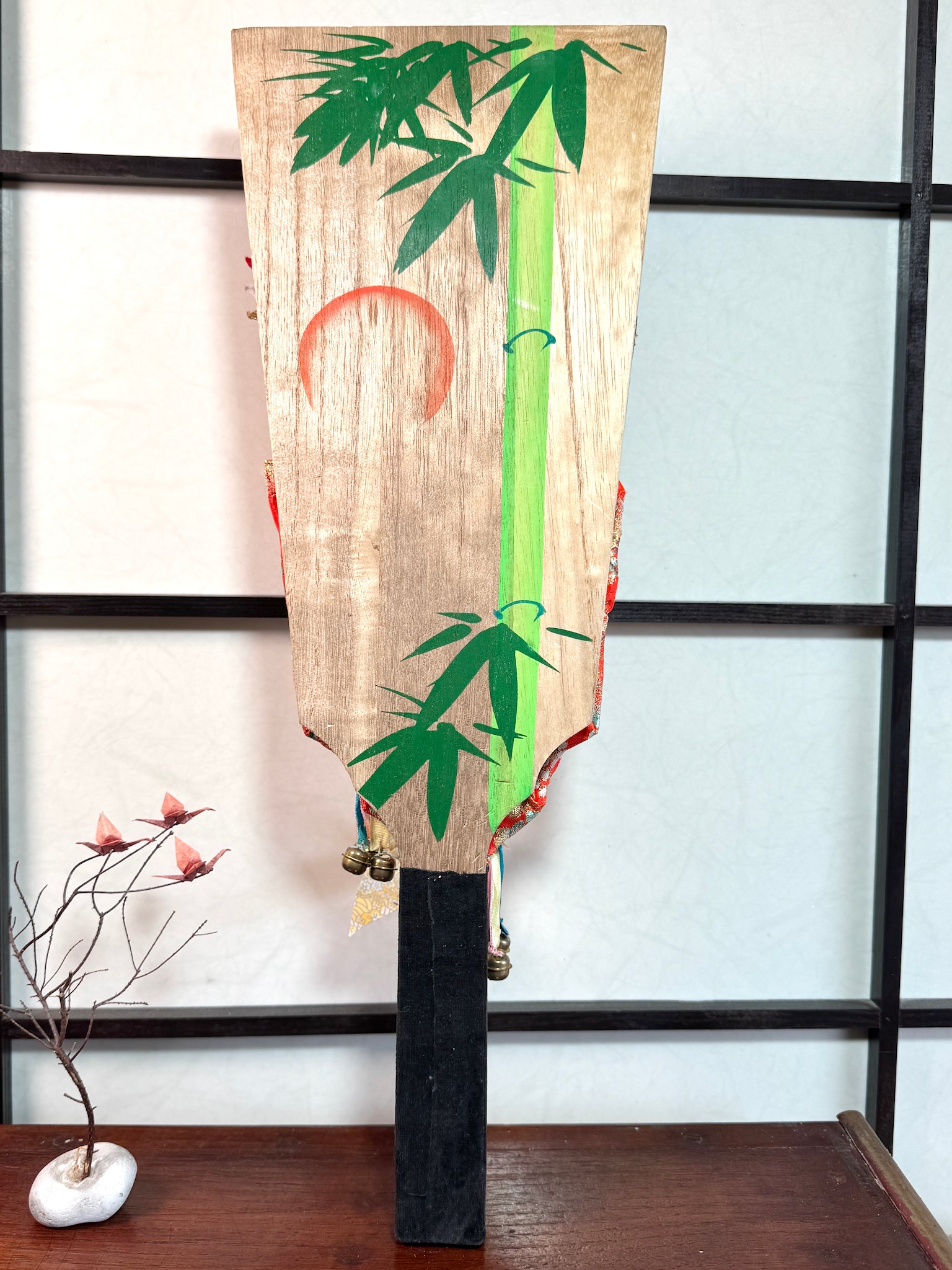raquette décorative japonaise hagoita, femme tenant une hagoita miniature, vu de dos motif bambou et soleil levant