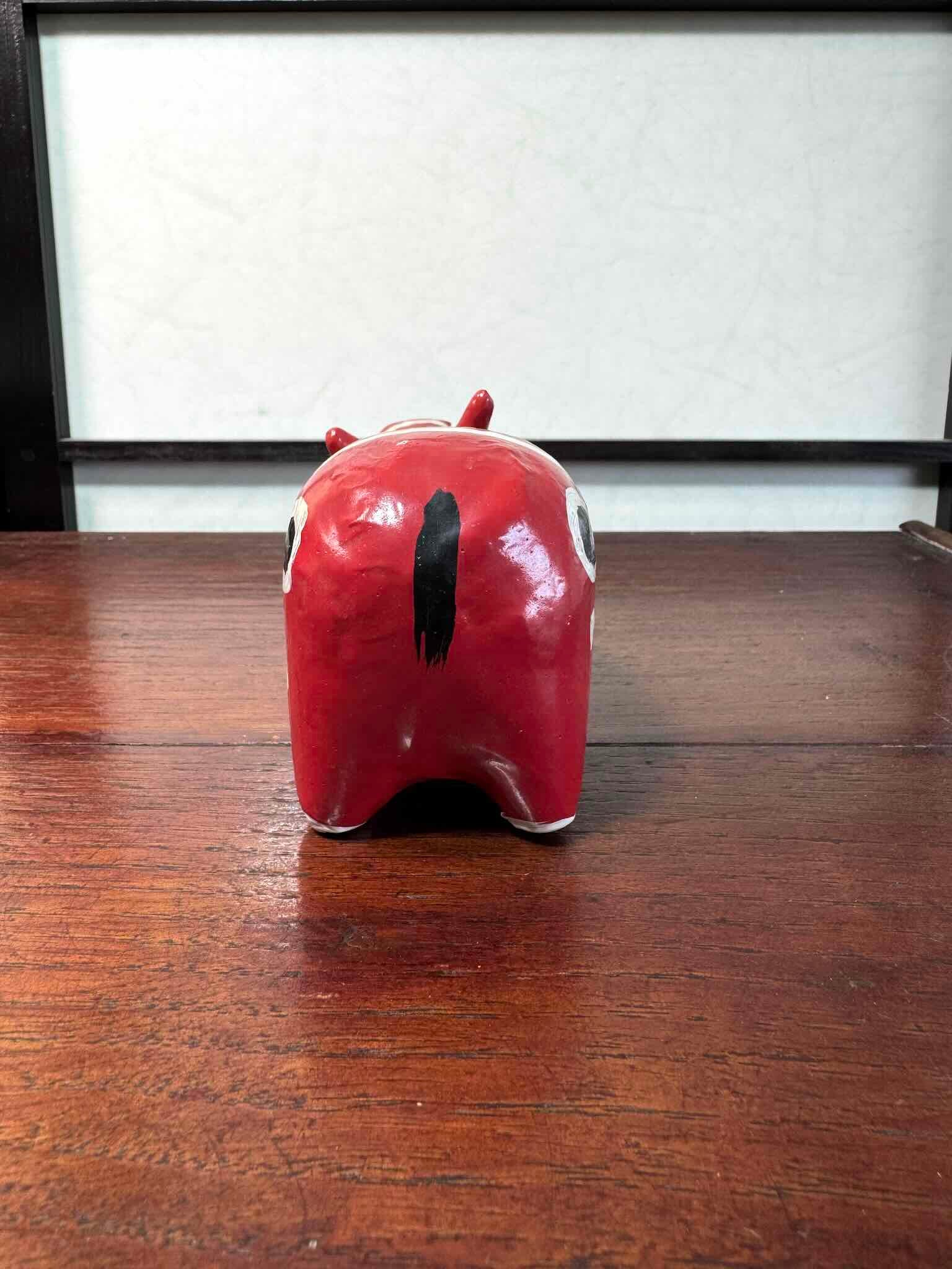 Akabeko japonais ancien rouge à pois blancs en papier mâché peint à la main, vu de dos