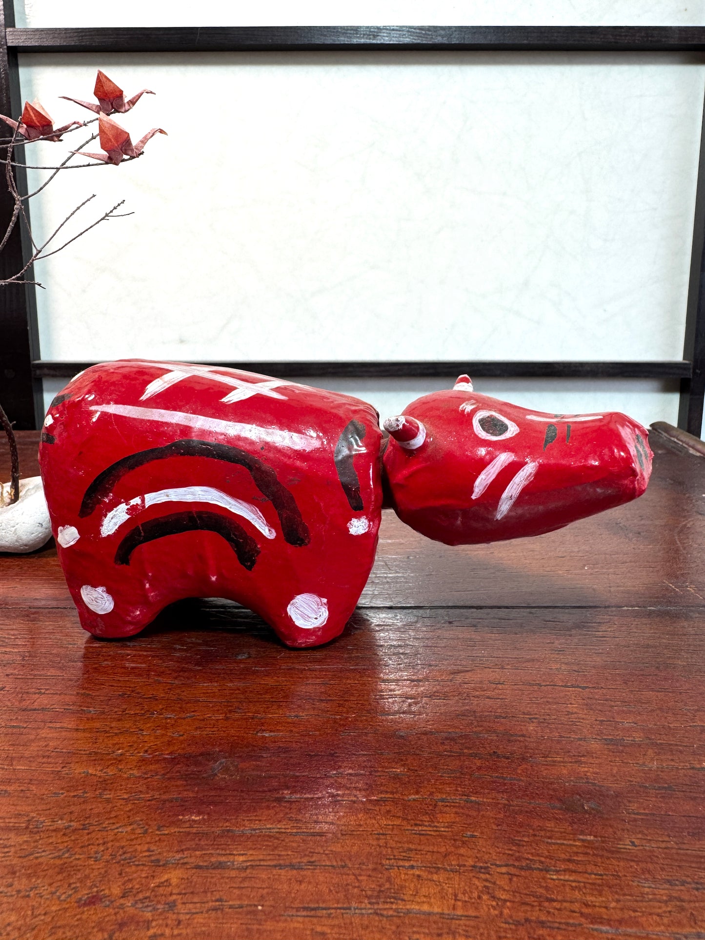 Akabeko japonais ancien rouge en papier mâché peint à la main, profil droit