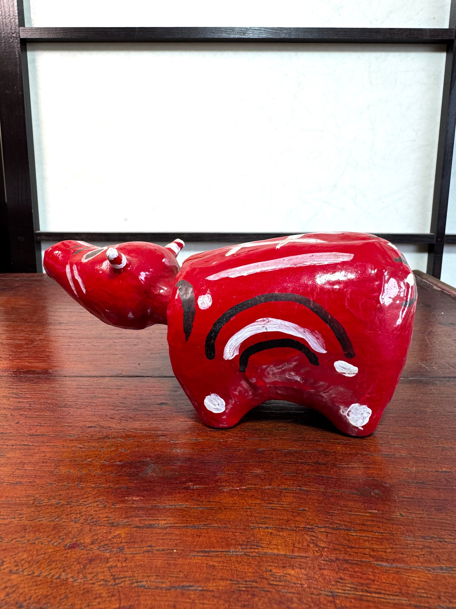 Akabeko japonais ancien rouge en papier mâché peint à la main, profil gauche