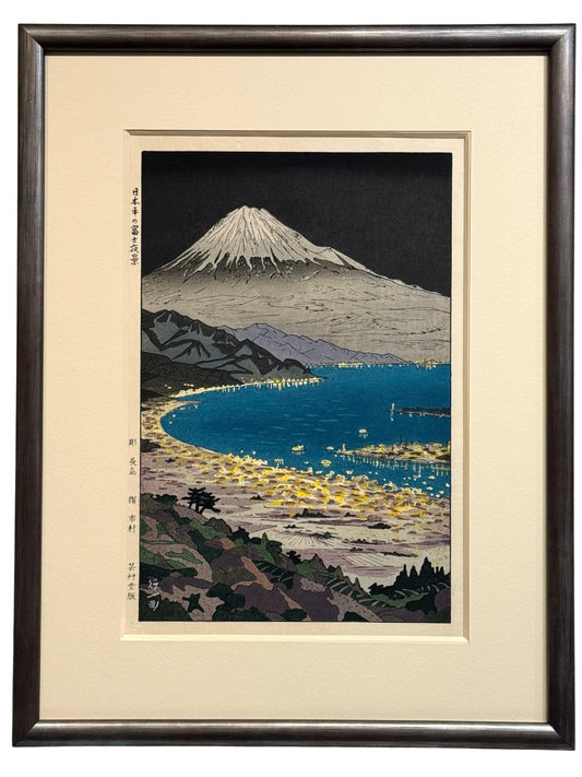 estampe japonaise encadrée de Okada Koichi le Mont Fuji vu de nuit avec la plage de Nihondara illuminée en premier plan, avec cadre méplat argent anthracité