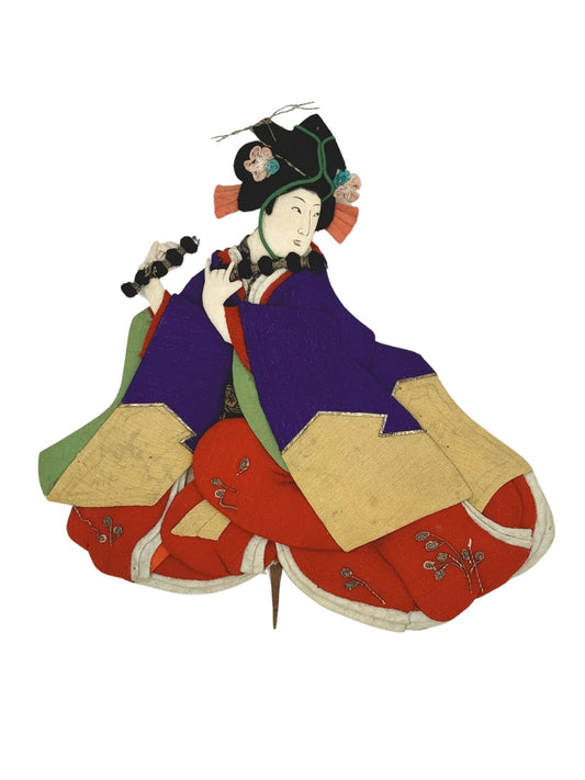 Okiyage japonais représentant une danseuse en kimono violet et rouge, tenant une grelottière de cérémonie, coiffée de fleurs en tissu.