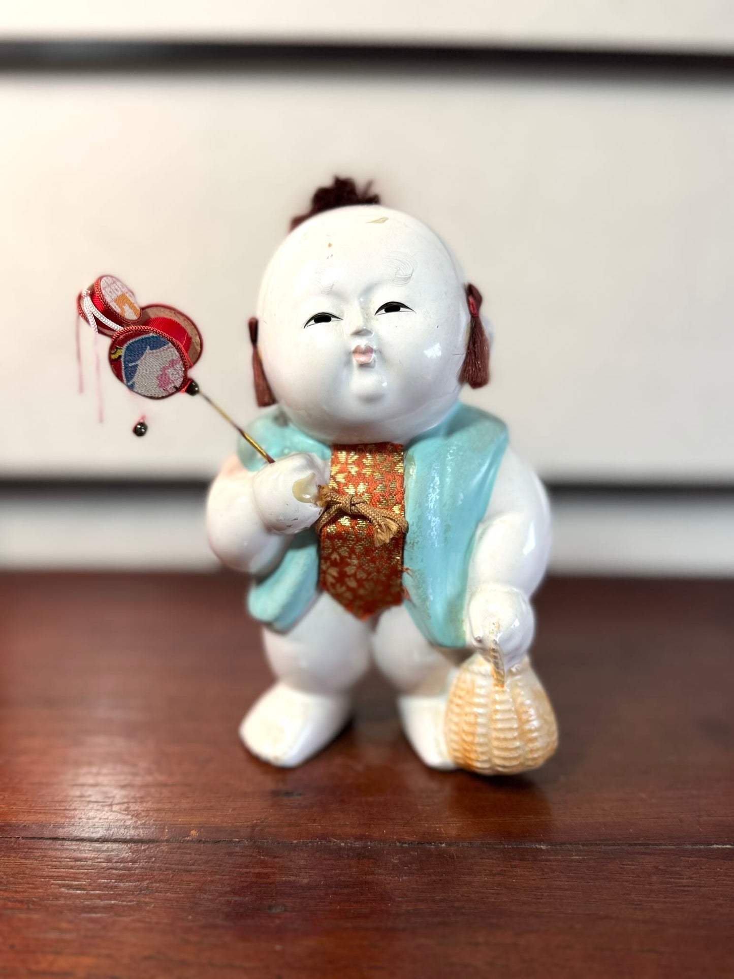 Gosho Ningyō ancien en céramique d’Hakata représentant un gosho, enfant japonais avec jouet et panier
