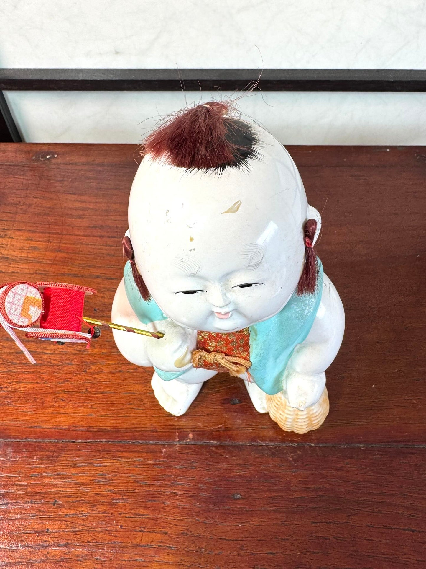 Gosho Ningyō ancien en céramique d’Hakata représentant un gosho, enfant japonais avec jouet et panier, vu de dessus