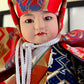 Poupée Ichimatsu, Benkei et sa cloche, visage de face, corde au cou, kimono orange bleu et rouge