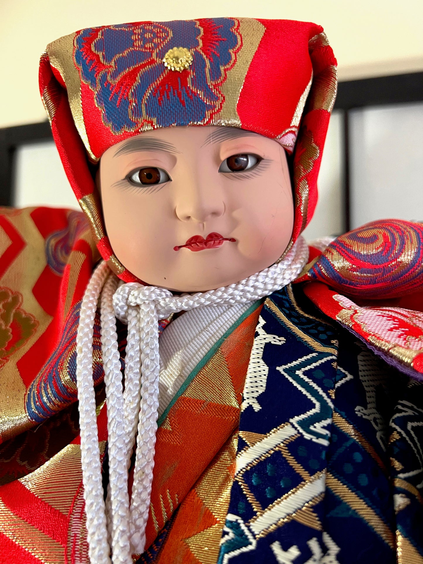 Poupée Ichimatsu, Benkei et sa cloche, visage de face, corde au cou, kimono orange bleu et rouge