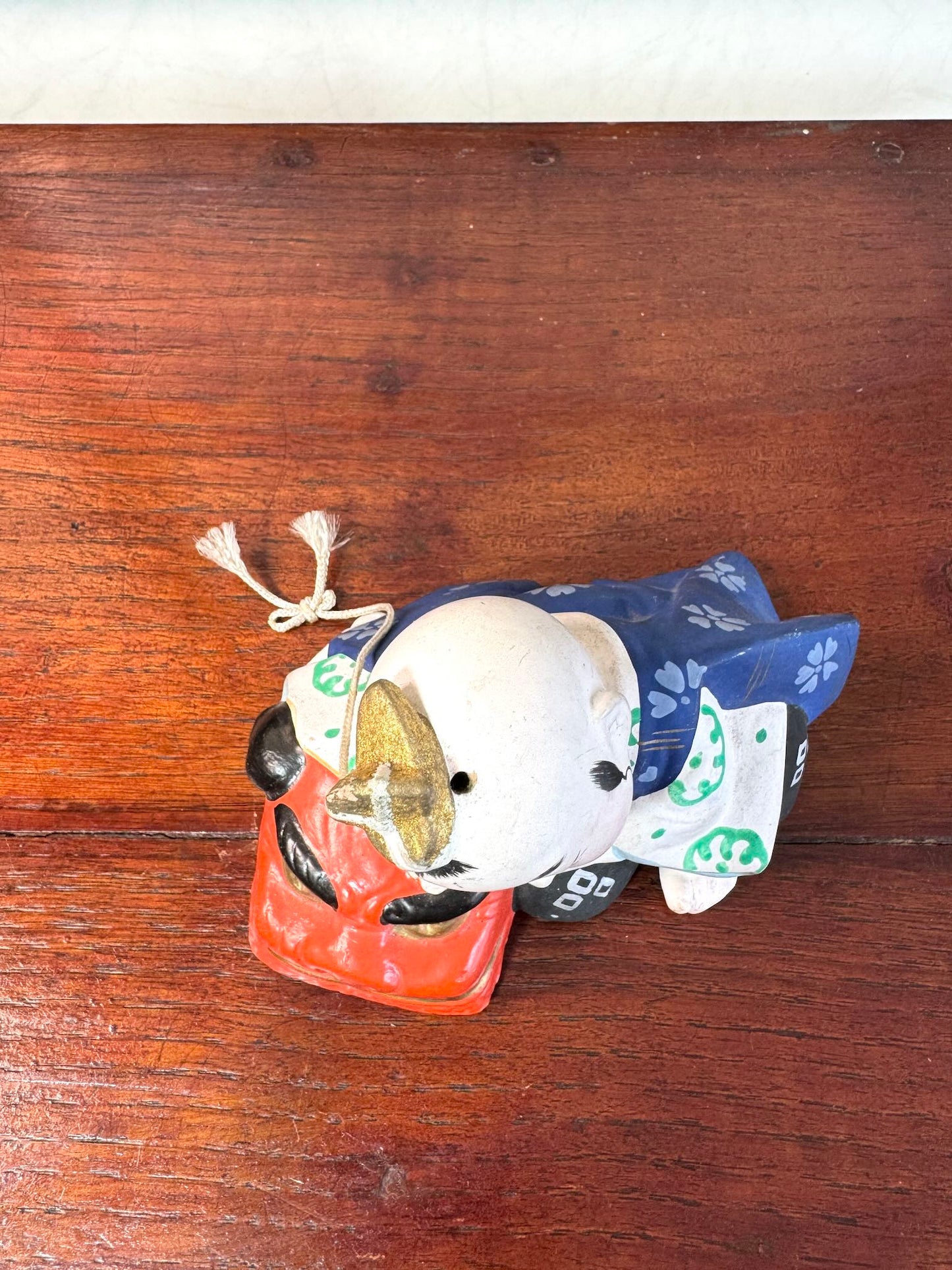 céramique japonaise,enfant endormi sur tete de lion shishi, vu de dessus