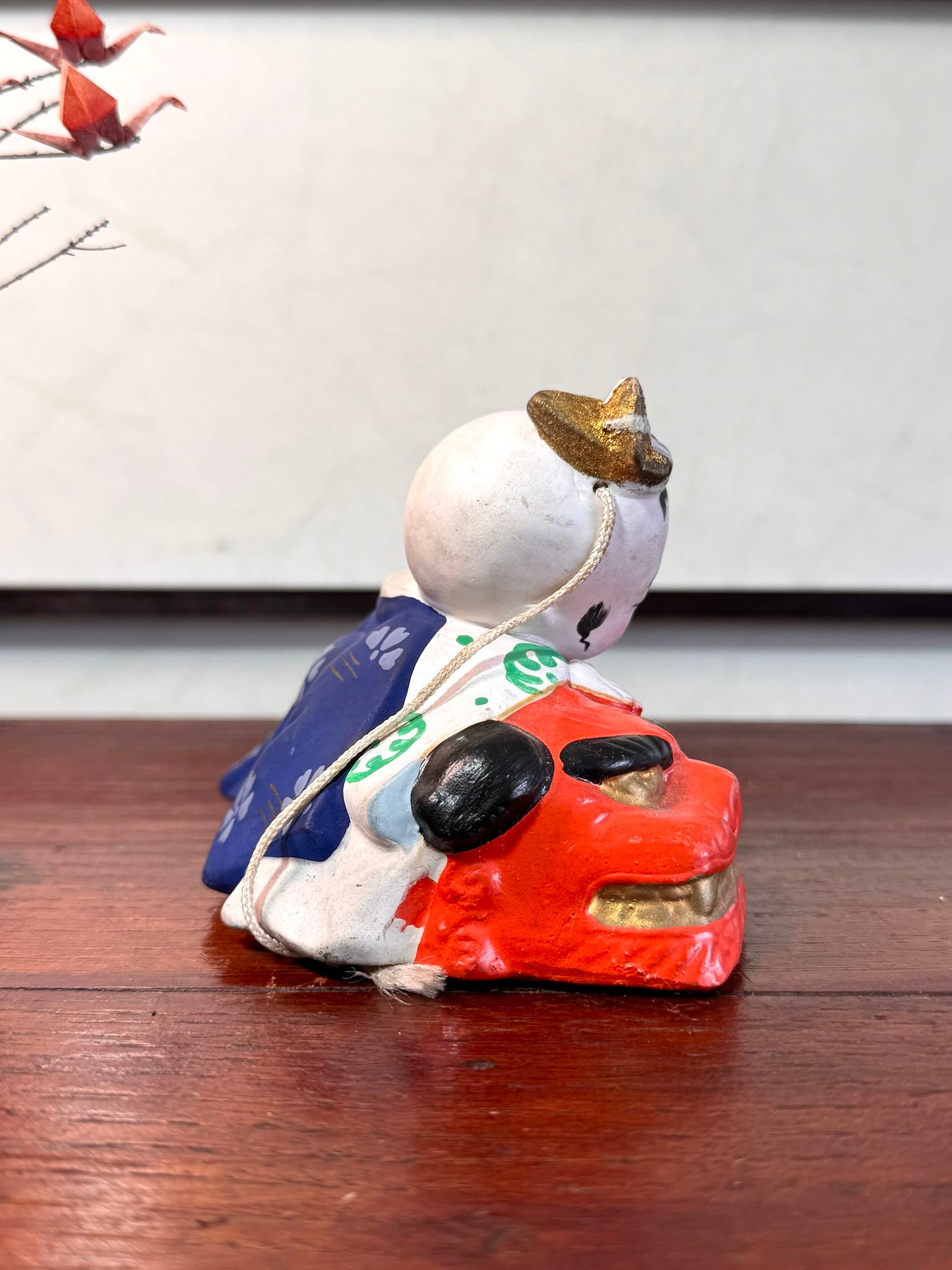 céramique japonaise,enfant endormi sur tete de lion shishi, vu du profil droit