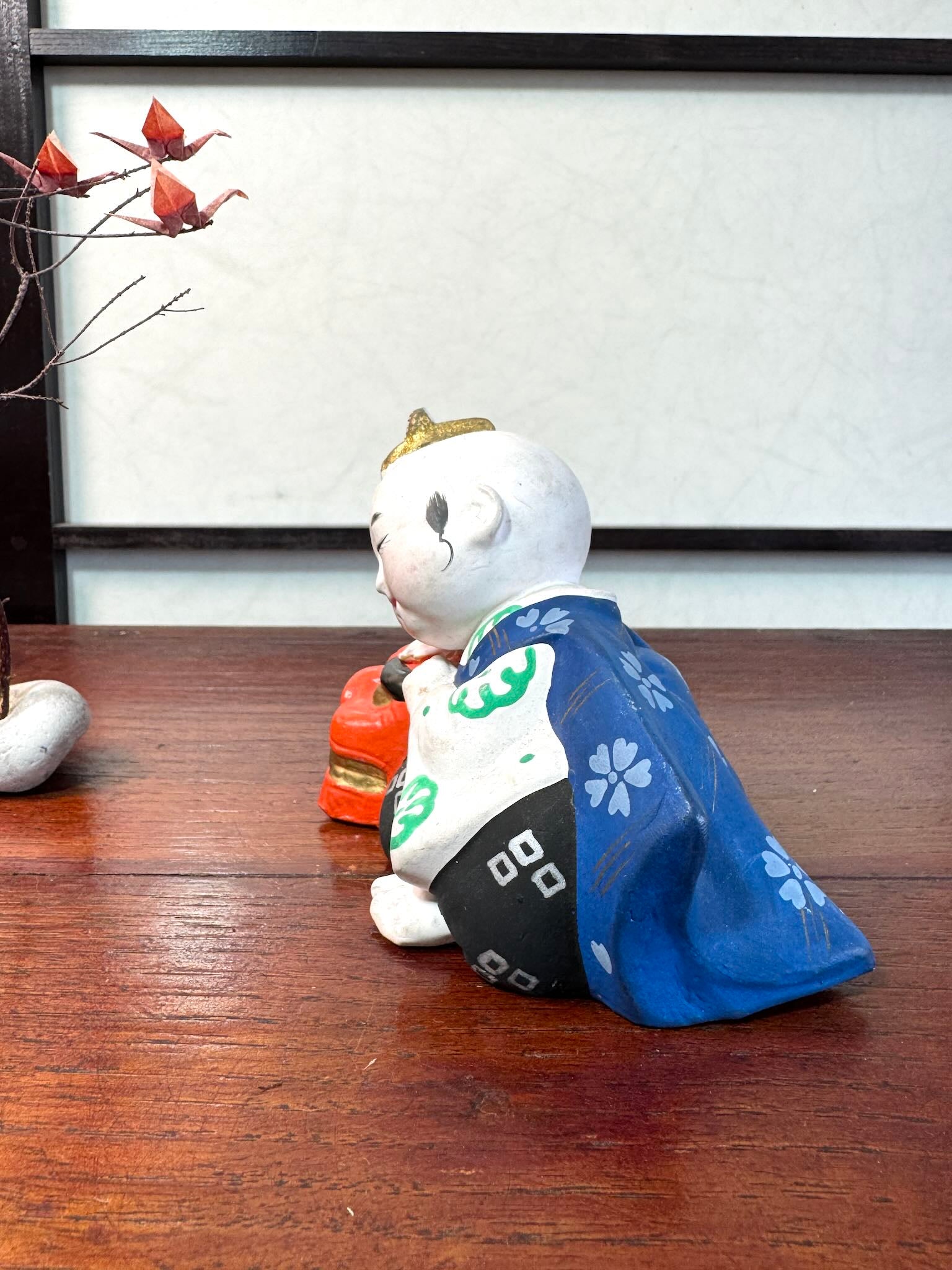 céramique japonaise,enfant endormi sur tete de lion shishi, vu du profil gauche