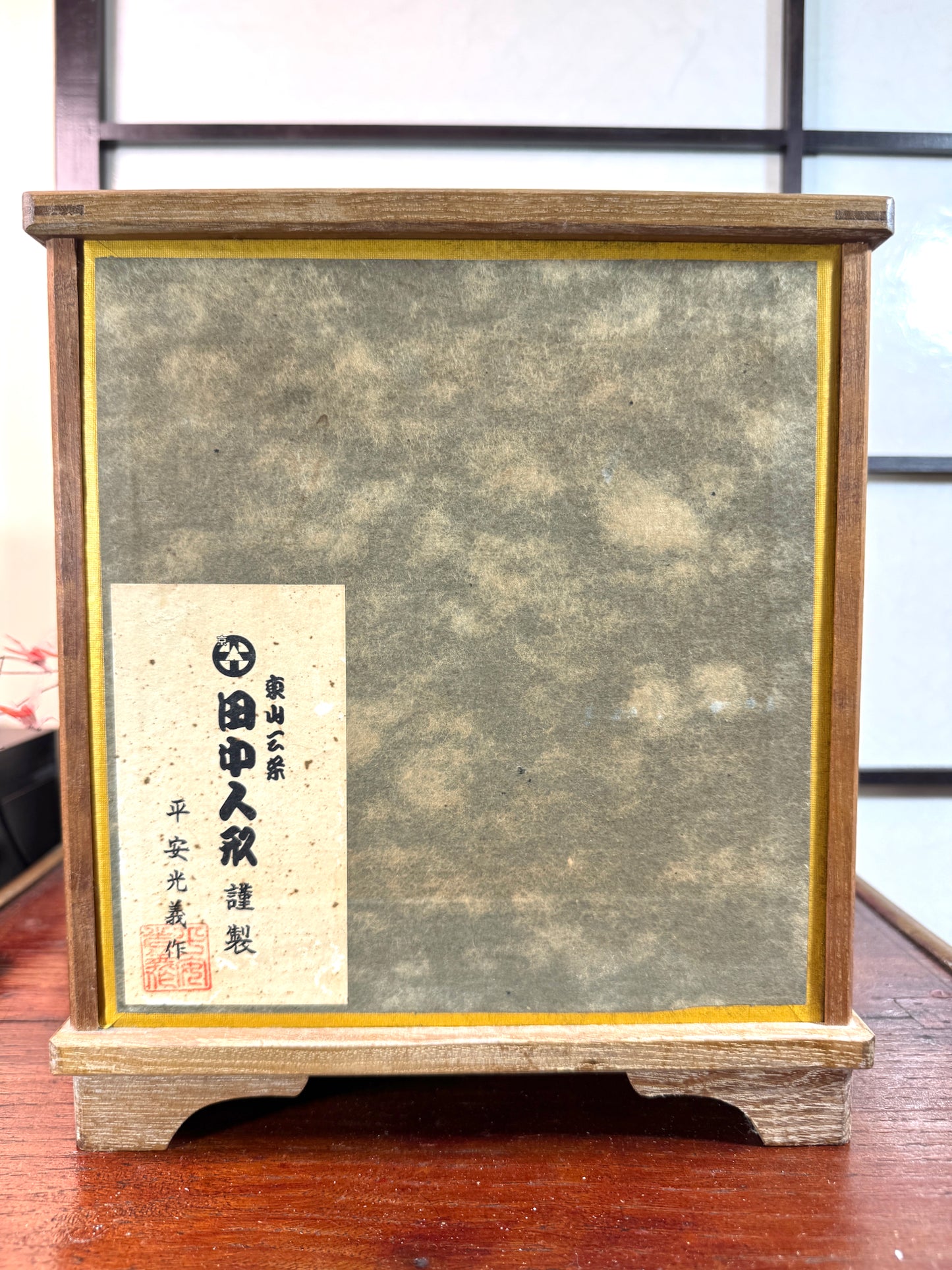 Dos de la vitrine avec inscription nom artiste et titre de la poupée