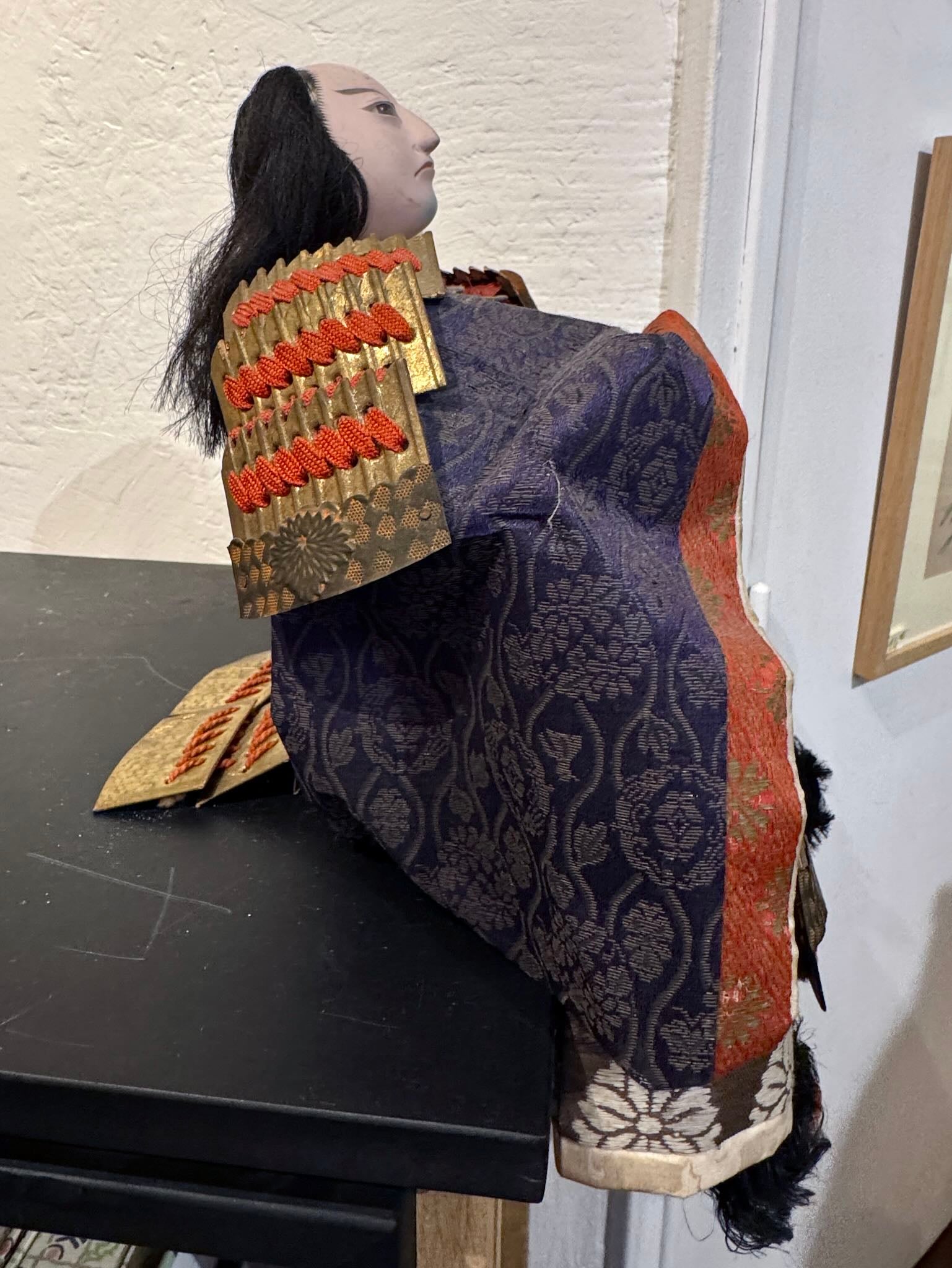 Poupée japonaise ancienne samouraï en armure rouge et or traditionnelle, profil droit