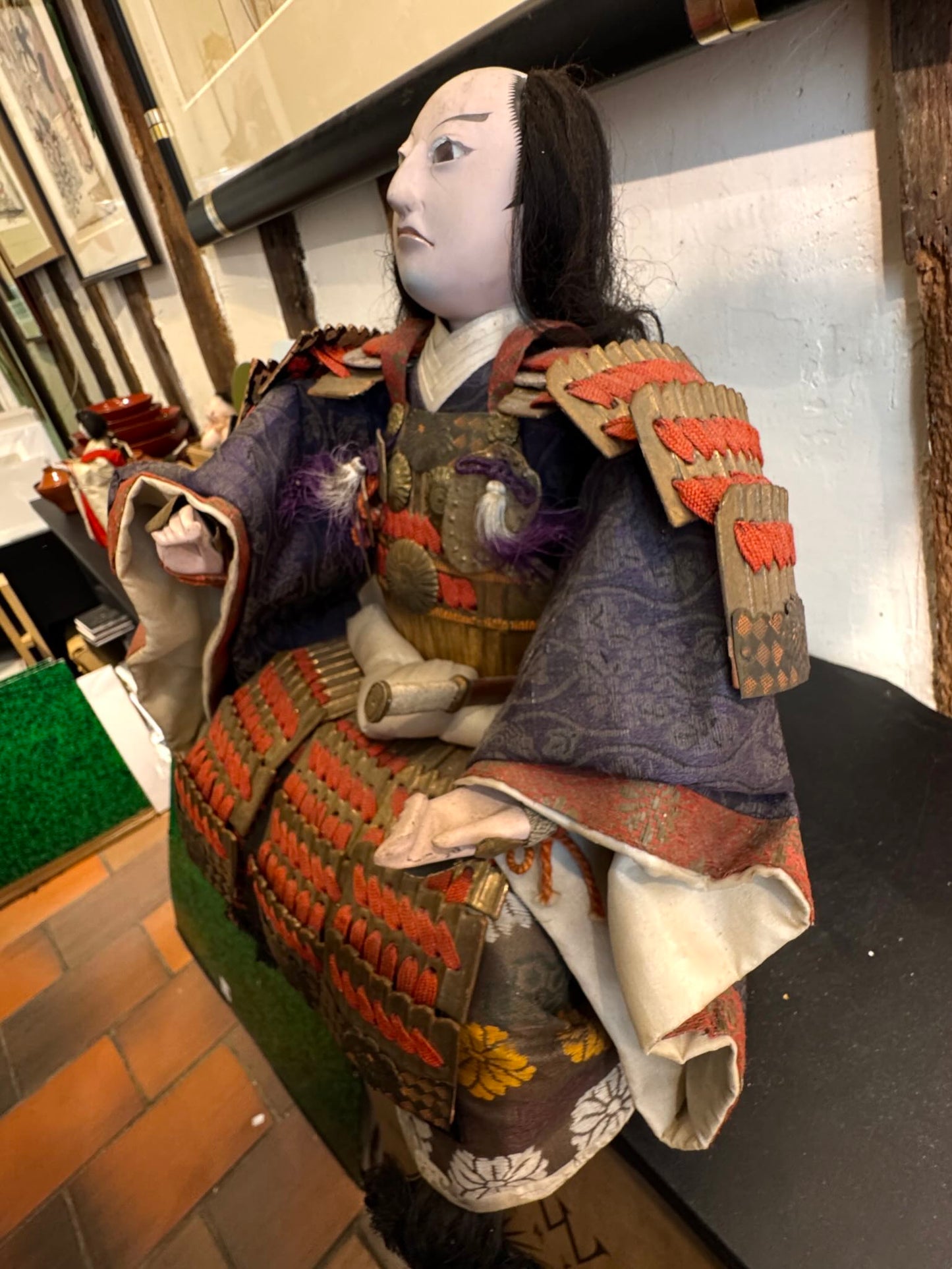 Poupée japonaise ancienne samouraï en armure rouge et or traditionnelle, profil gauche