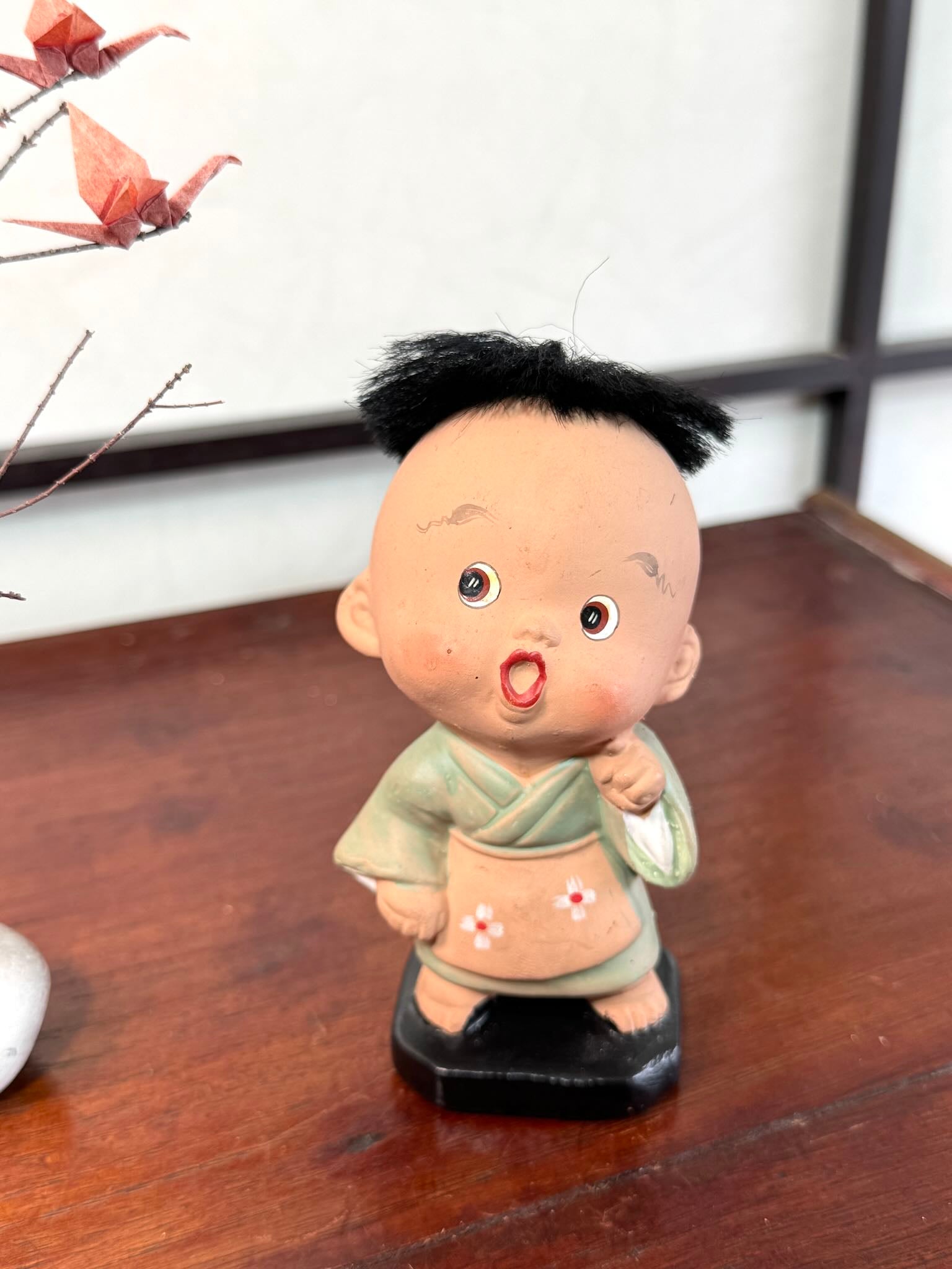 Figurine japonaise ancienne d’enfant étonné en céramique avec cheveux noirs