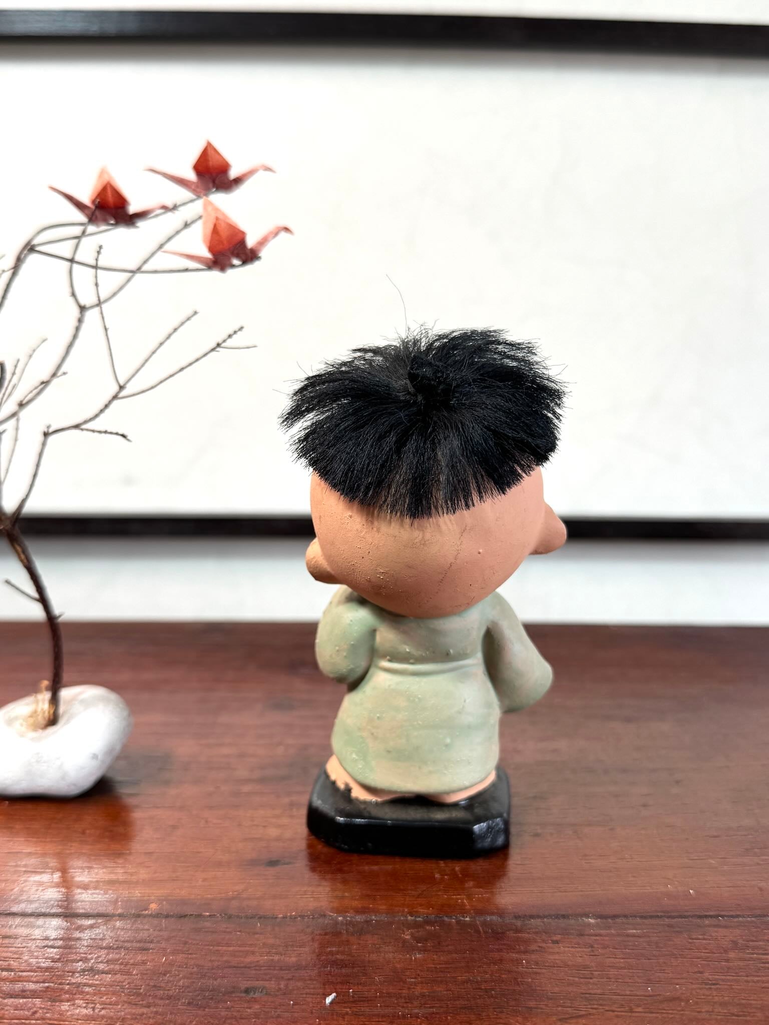 Figurine japonaise ancienne d’enfant étonné en céramique avec cheveux noirs, vu de dos