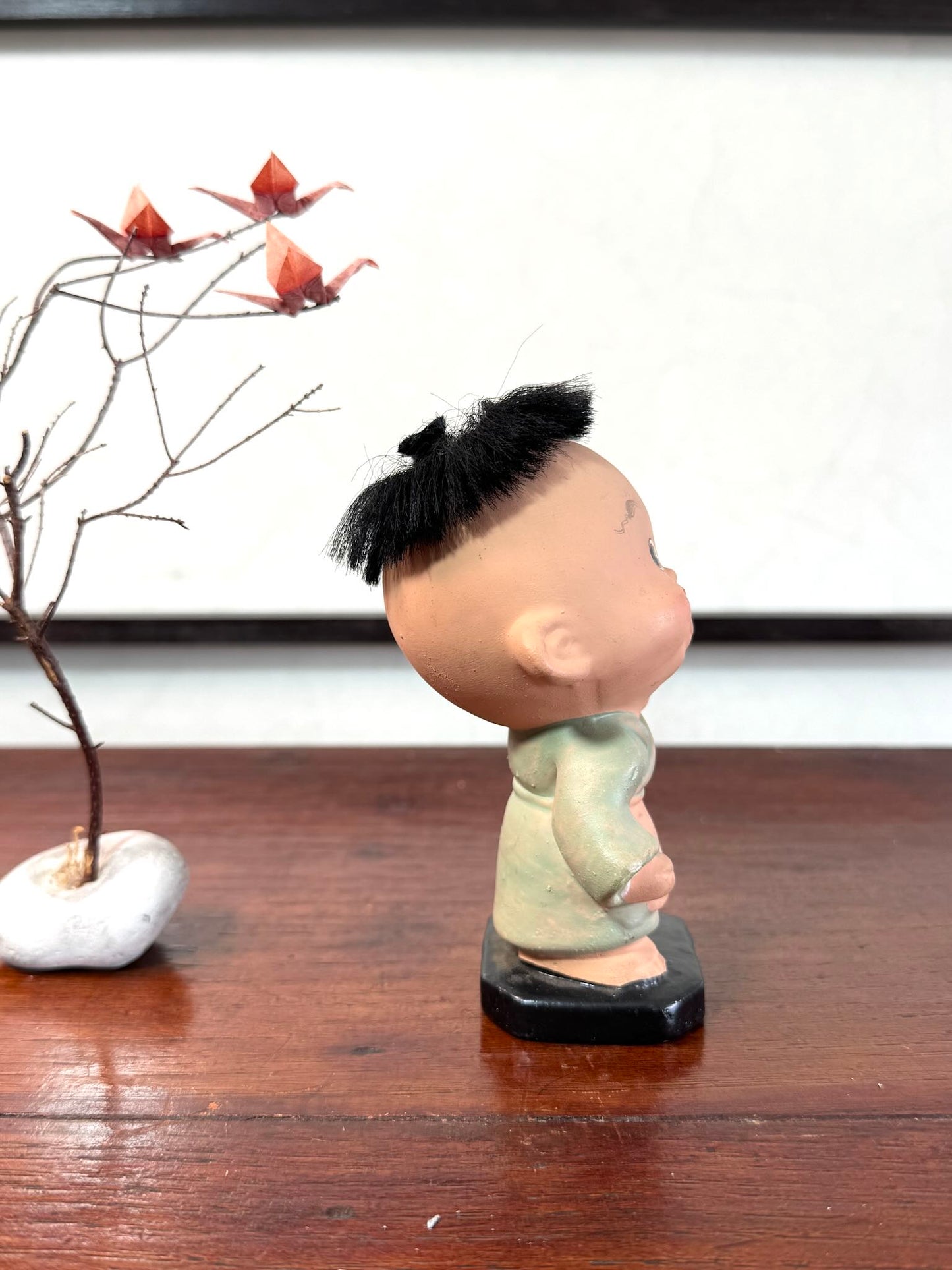Figurine japonaise ancienne d’enfant étonné en céramique avec cheveux noirs, le profil droit