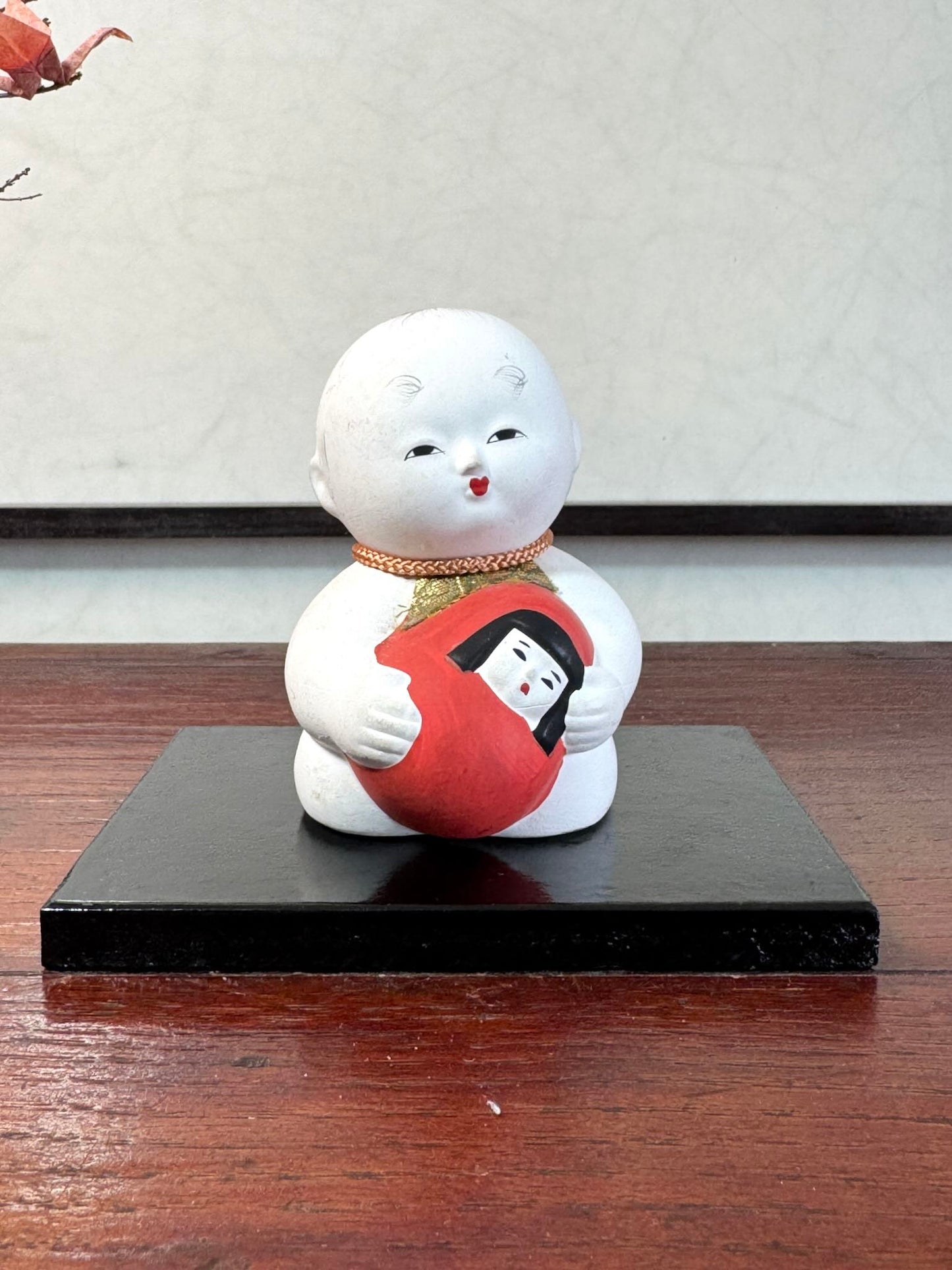 Gosho Ningyō en céramique tenant un Hime Daruma rouge japonais, de face