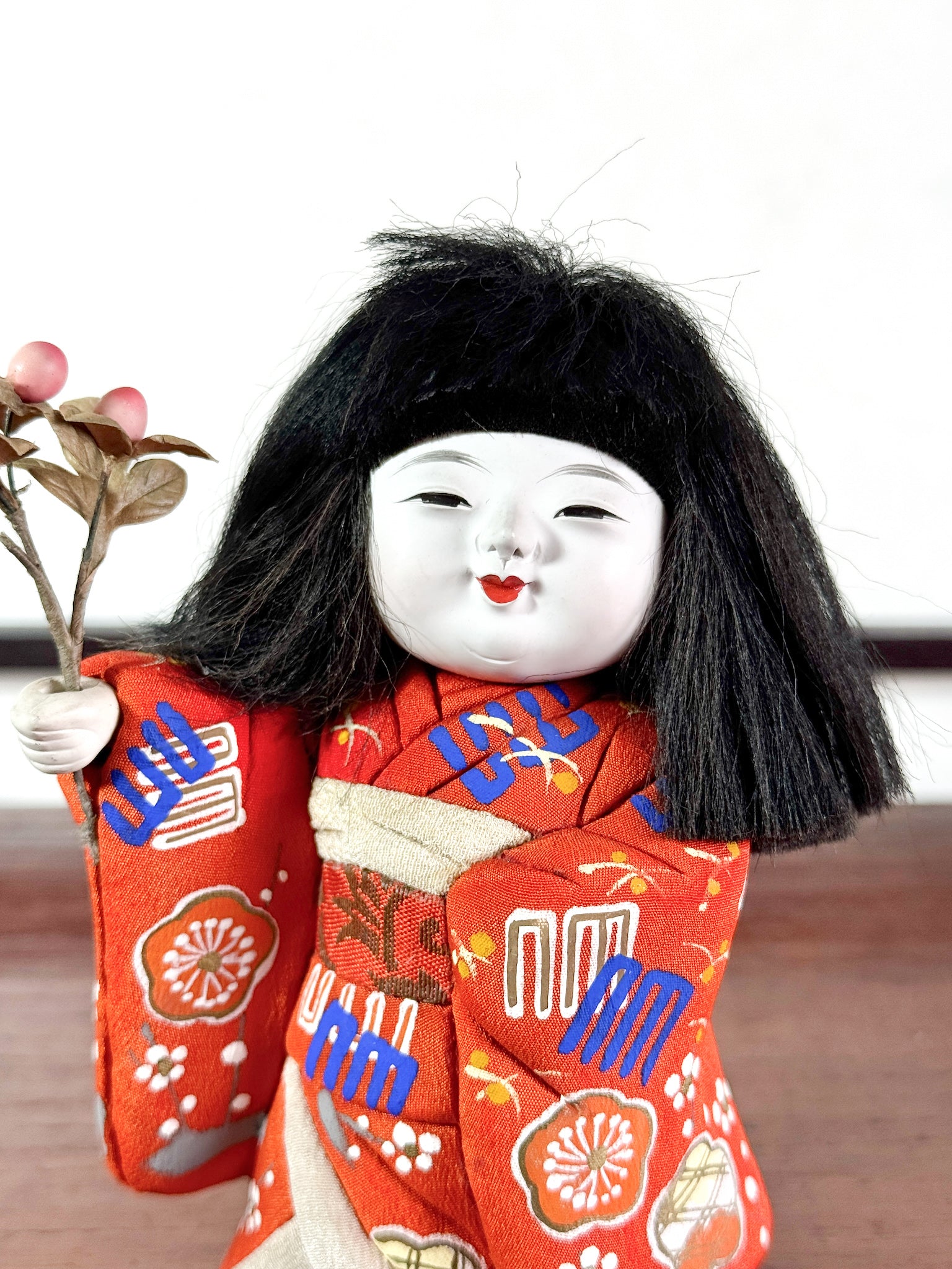 poupée japonaise en kimono rouge avec bouquet de fleurs, gros plan sur le visage