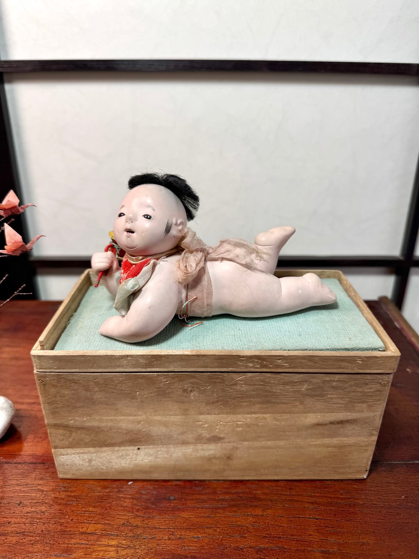 Poupée japonaise ancienne bébé couché en terre cuite sur boite en bois