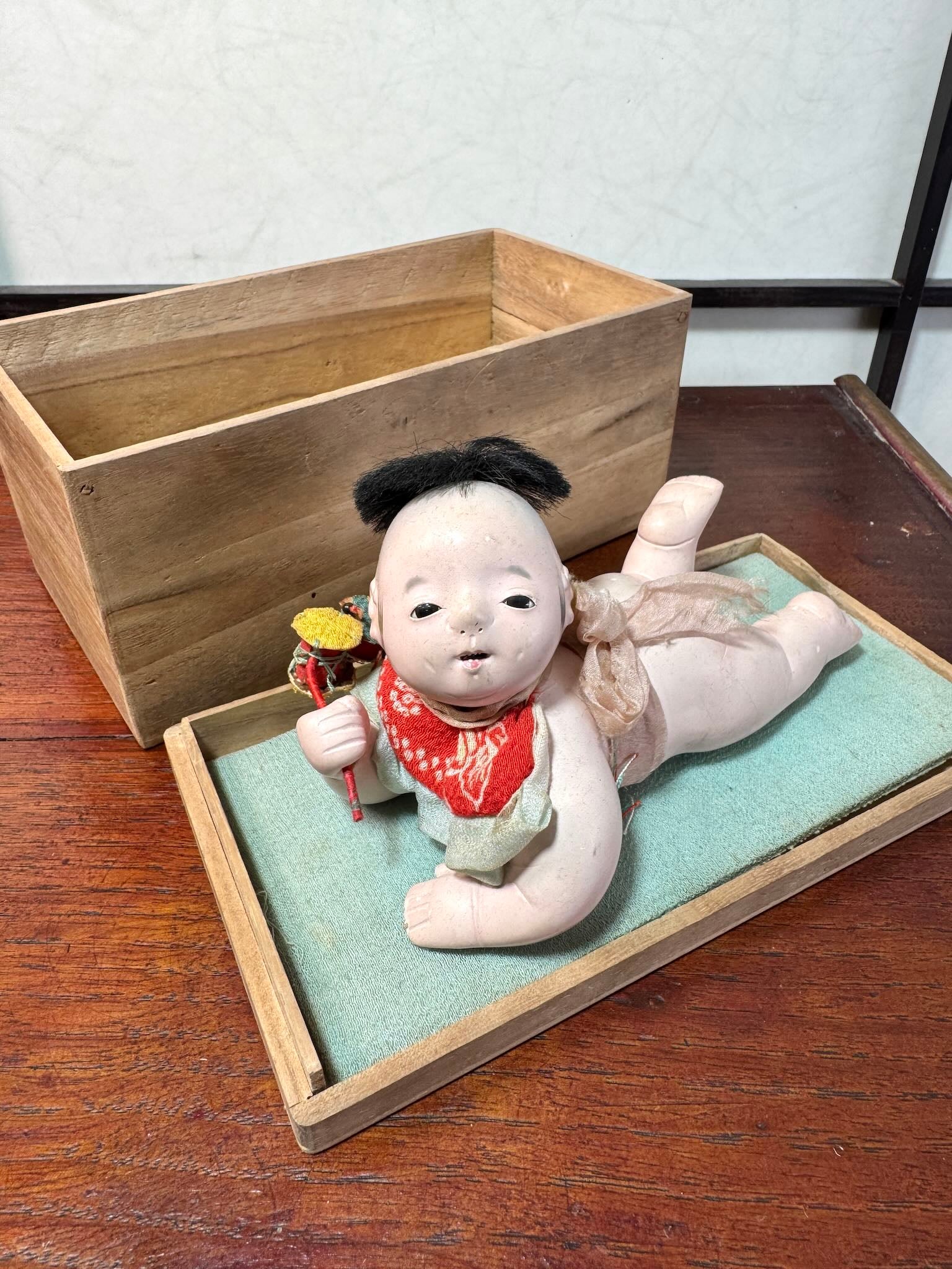 Poupée japonaise ancienne bébé couché en terre cuite sur boite en bois, détail