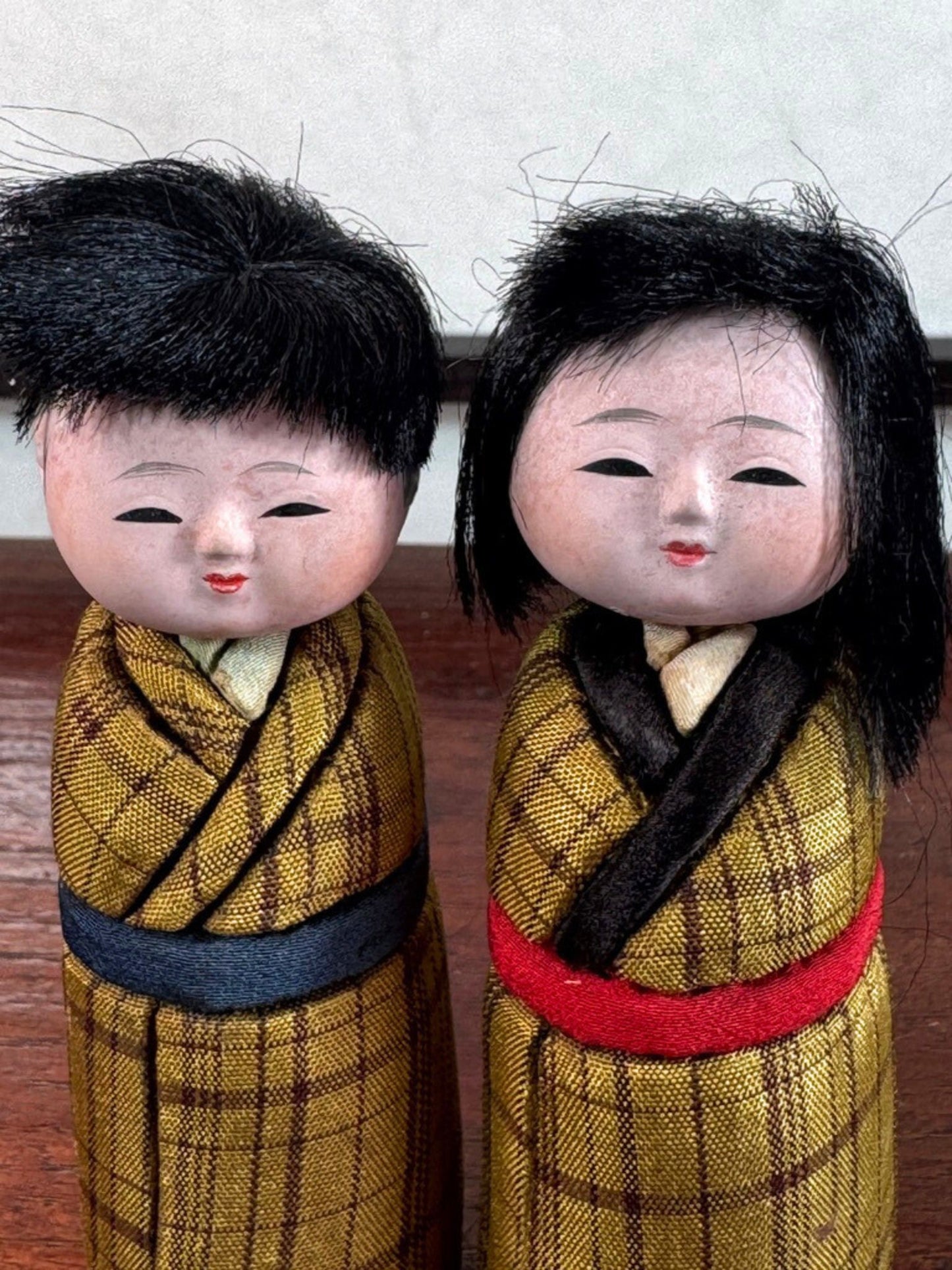 Couple de poupées japonaise kimekomi en kimono jaune, gros plan sur les visages