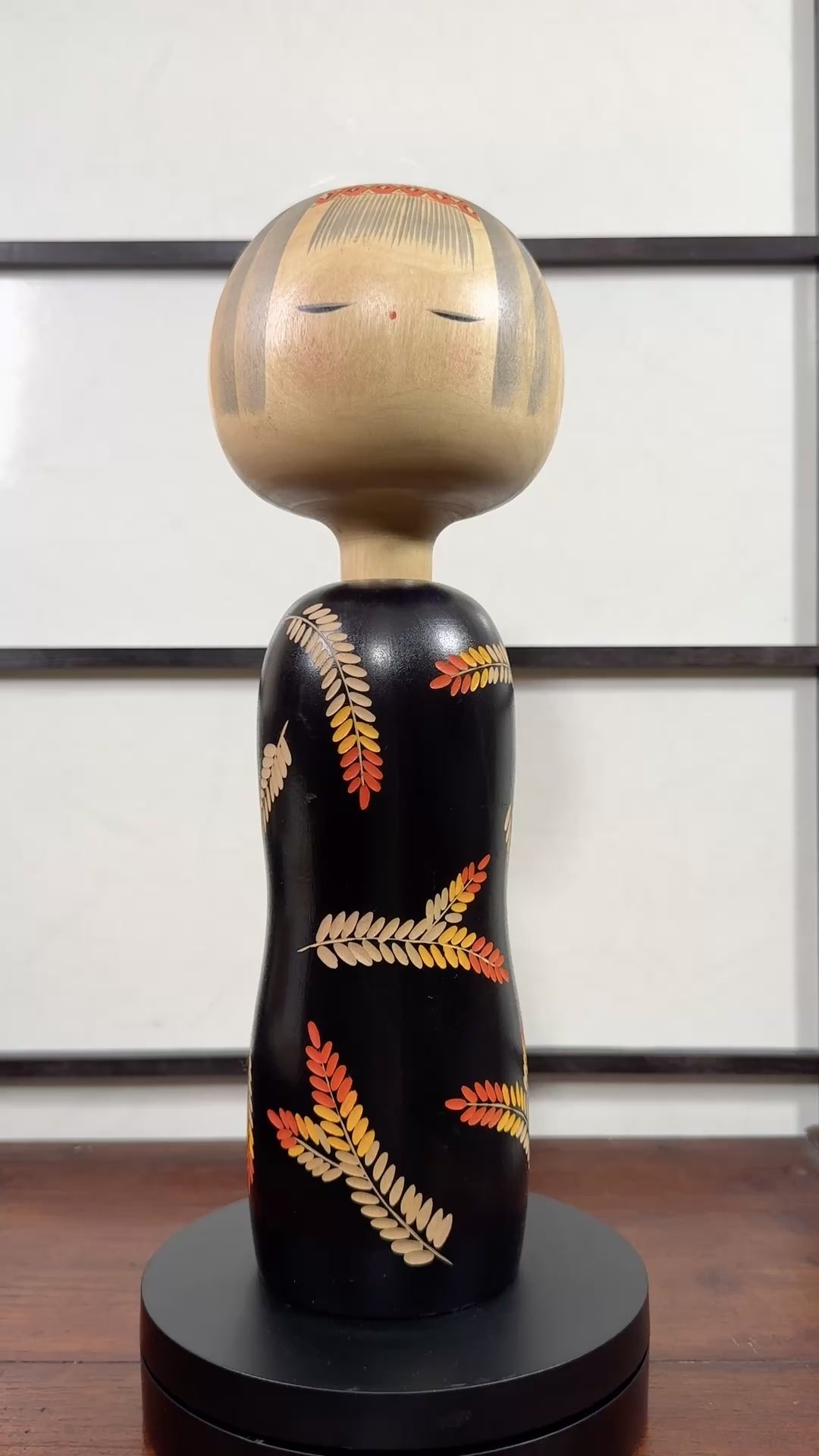 Grande kokeshi vintage de Yuji Kawase au corps noir décoré d’épis de riz beige, jaunes et rouges, Japon, période Shōwa. La vidéo à 360 degrés