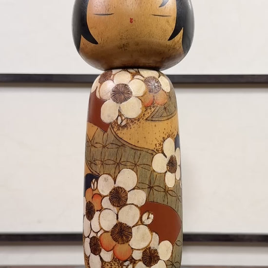 Kokeshi vintage de Yuji Kawase datée de 1985, au petit chignon et kimono orné de fleurs blanches gravées évoquant le cerisier ou le prunier, la vidéo à 360 degrés