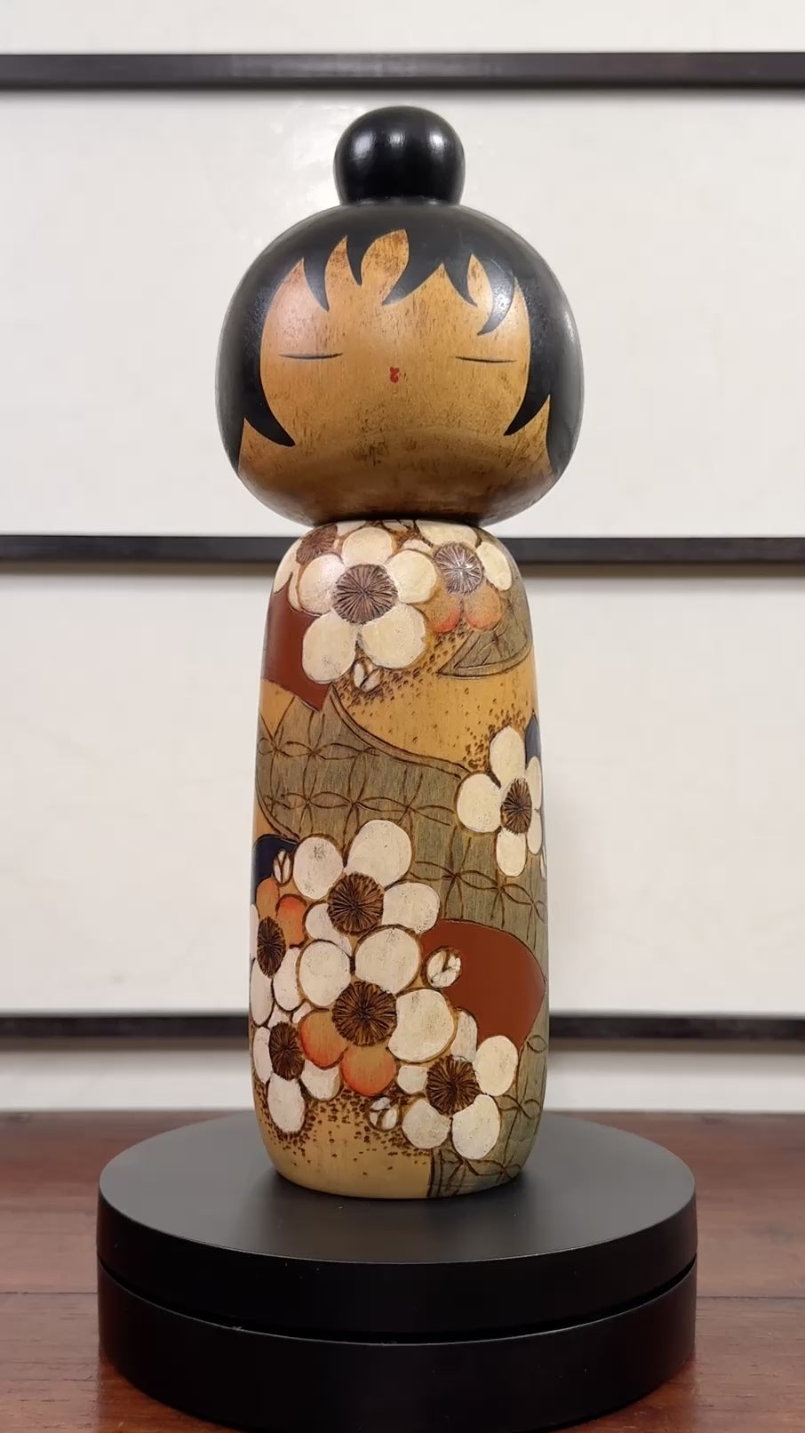 Kokeshi vintage de Yuji Kawase datée de 1985, au petit chignon et kimono orné de fleurs blanches gravées évoquant le cerisier ou le prunier, la vidéo à 360 degrés