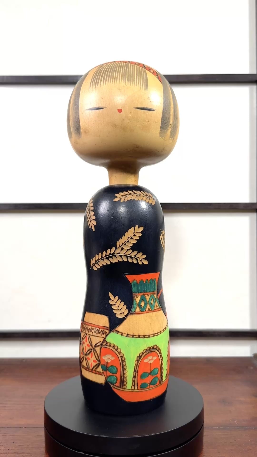 Kokeshi vintage de Yuji Kawase au corps noir décoré d’épis de riz et de deux récipients colorés à motifs géométriques, la vidéo à 360 degrés