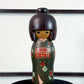 kokeshi gunma de Sadao Kishi au kimono vert, fleurs stylisées et obi rouge à carreaux, la vidéo de présentation à 360 degrés
