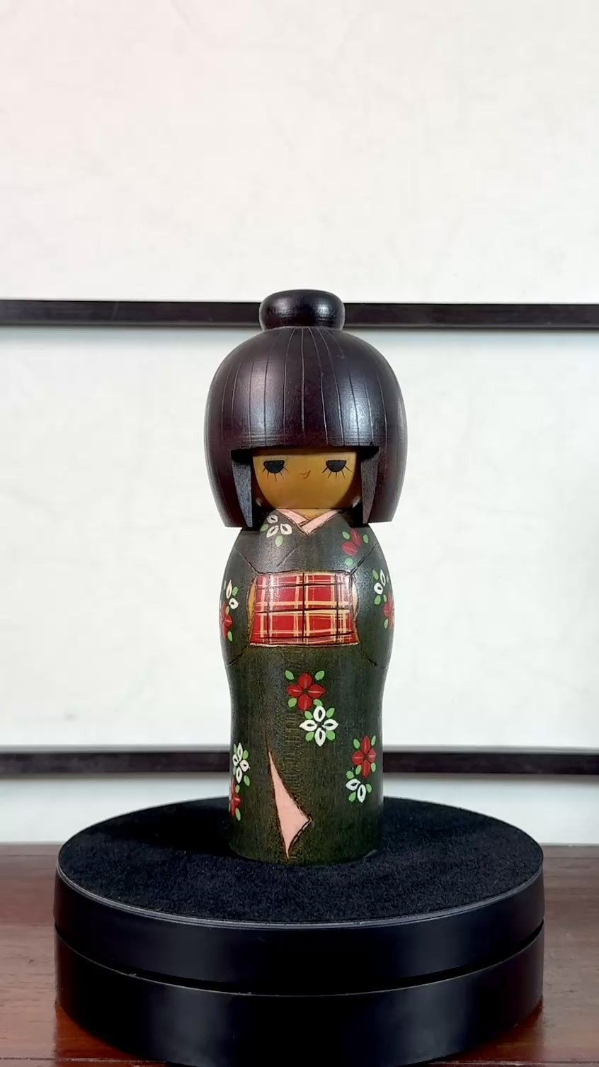 kokeshi gunma de Sadao Kishi au kimono vert, fleurs stylisées et obi rouge à carreaux, la vidéo de présentation à 360 degrés