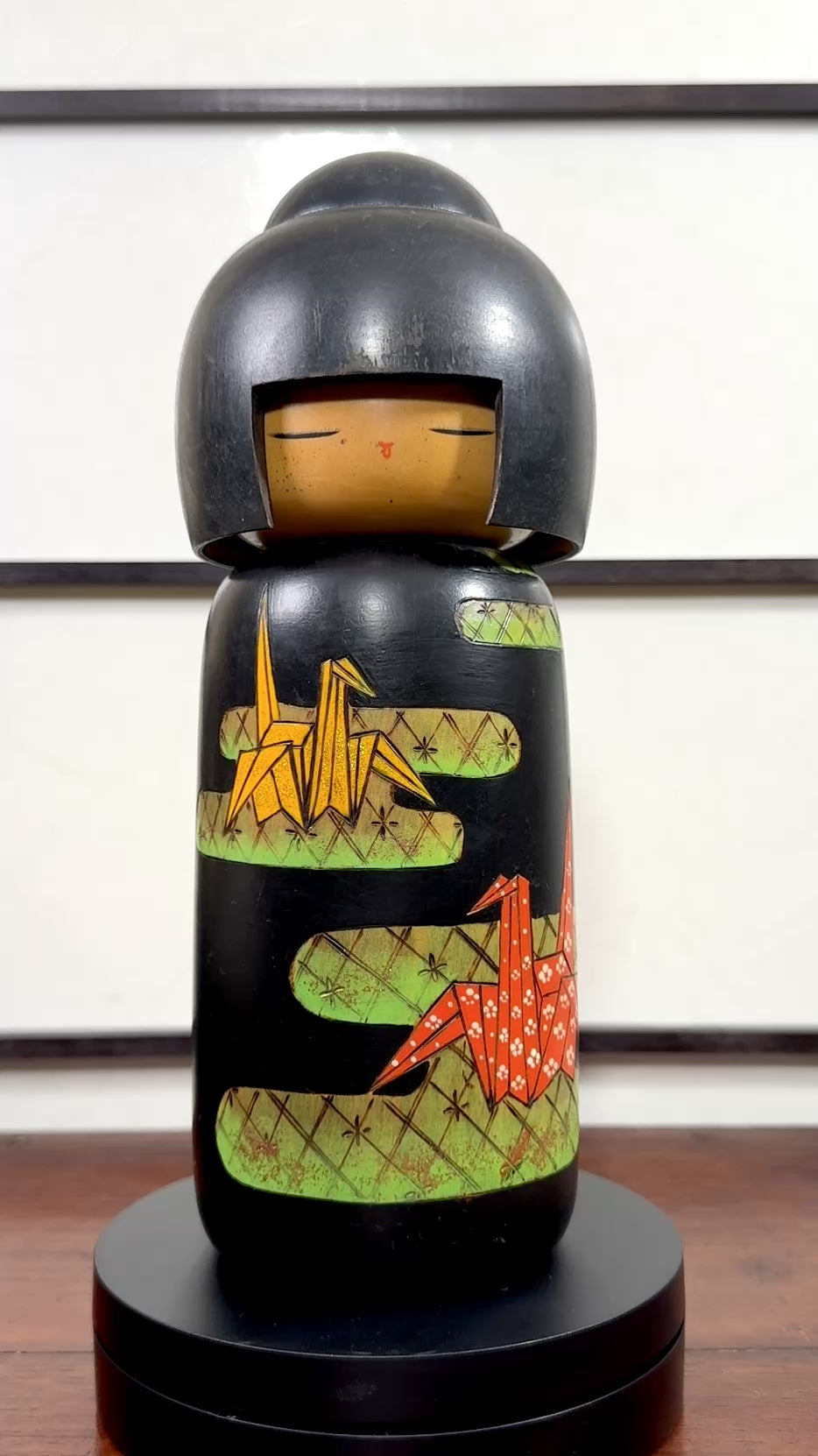 Kokeshi vintage de Yuji Kawase datée de 1992, décorée de grues en origami jaunes et rouges sur un corps noir., la vidéo à 360 degrés