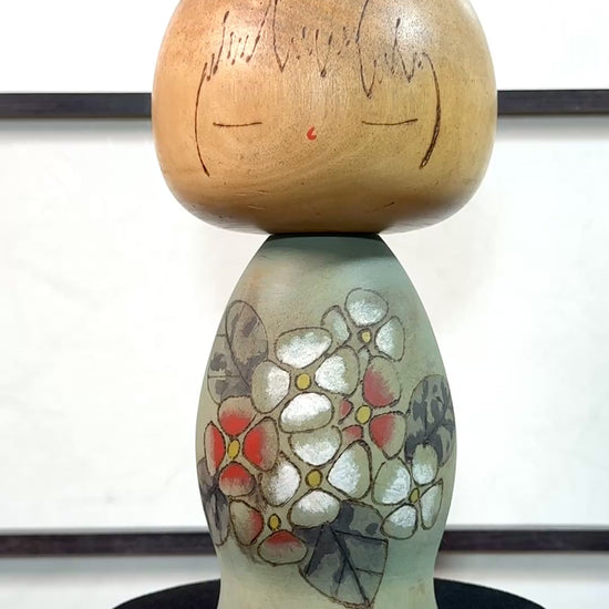 Kokeshi Yuji Kawase de 1979 à décor floral vert, rouge et blanc la vidéo à 360 degrés
