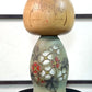 Kokeshi Yuji Kawase de 1979 à décor floral vert, rouge et blanc la vidéo à 360 degrés