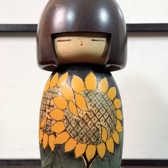 Kokeshi vintage japonaise de Yuji Kawase ornée de grands tournesols jaunes gravés et peints sur fond vert et noir, la vidéo à 360 degrés